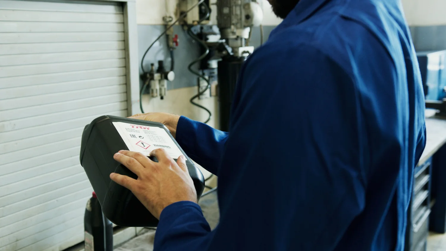 Technician using a handheld diagnostic tester in the workshop