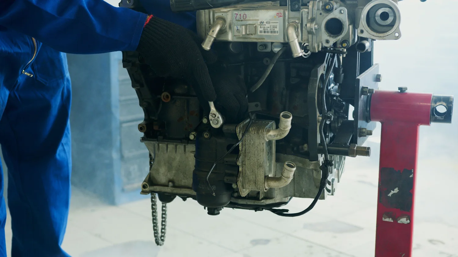 Mechanic carrying out hands-on component repair on an engine