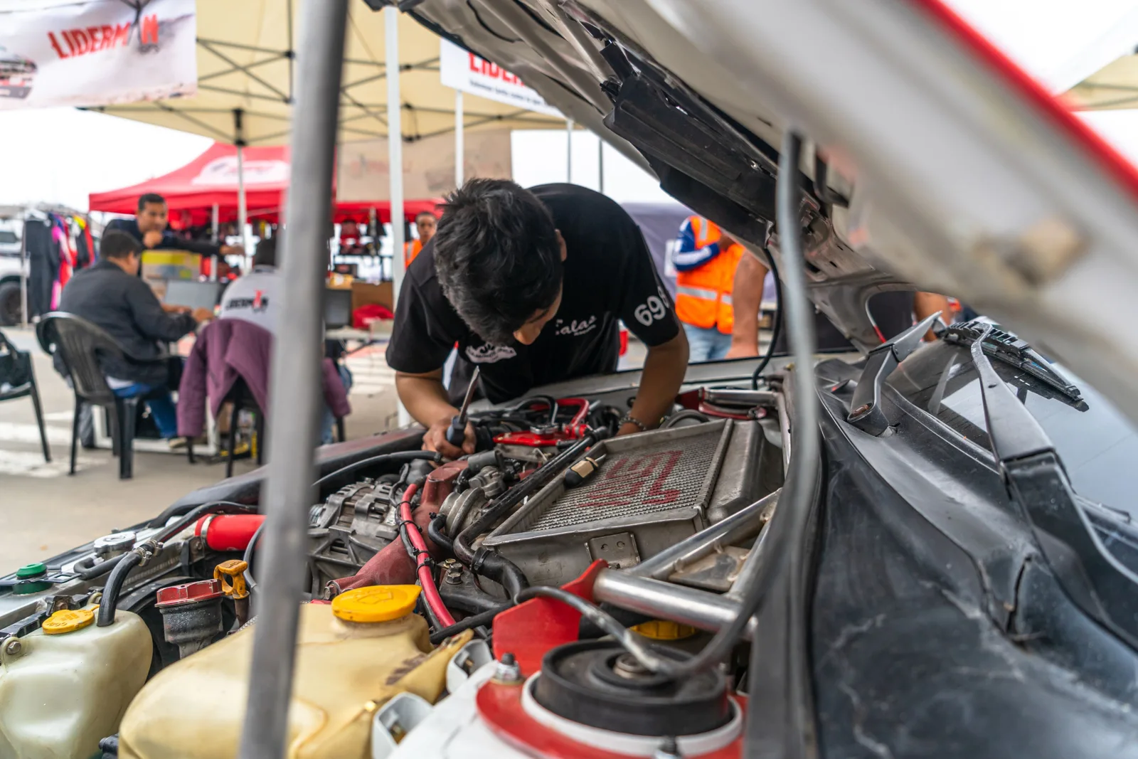 Technician inspecting the components in an open engine bay